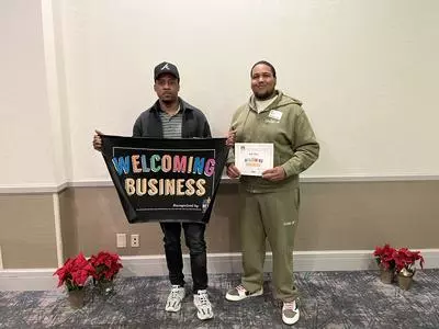 Sole Play ATL CEO and Owner TJ Bennett and Store Manager William Browning posing for a photo holding Welcoming Business mat
