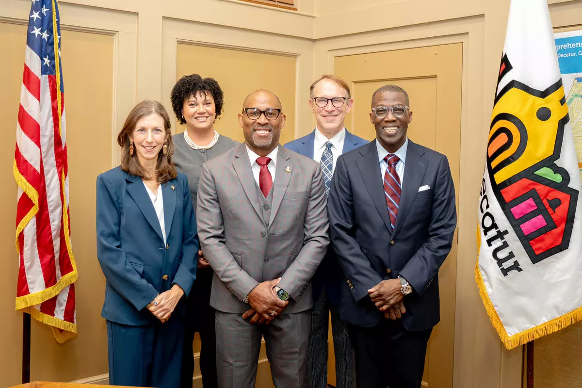 2026 Decatur City Commission members standing between the American flag and City of Decatur flag.