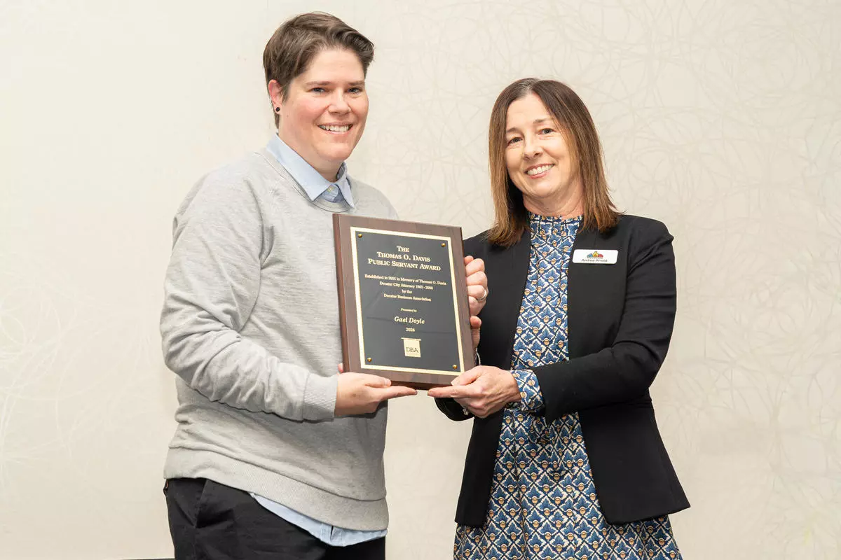 Left: award recipient Gael Doyle standing next to City Manager Andrea Arnold on right. Both holding plaque.